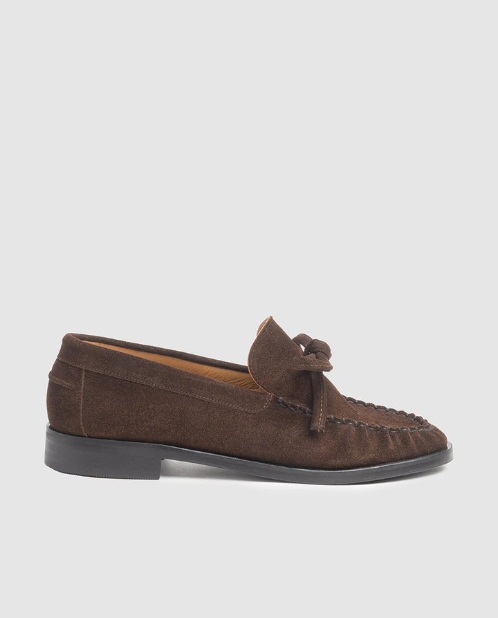 Vista de perfil del mocasín plano Estela en piel serraje color chocolate con lazo