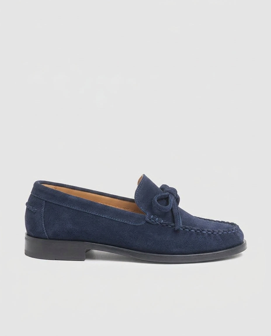 Vista de perfil del mocasín plano Julia en piel serraje azul marino con lazo