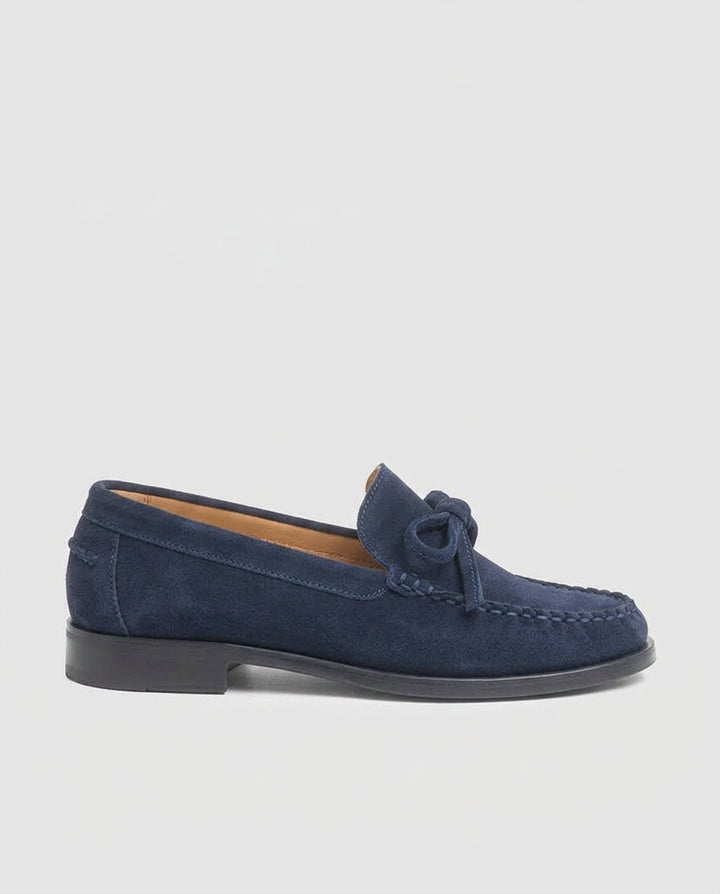 Vista de perfil del mocasín plano Julia en piel serraje azul marino con lazo