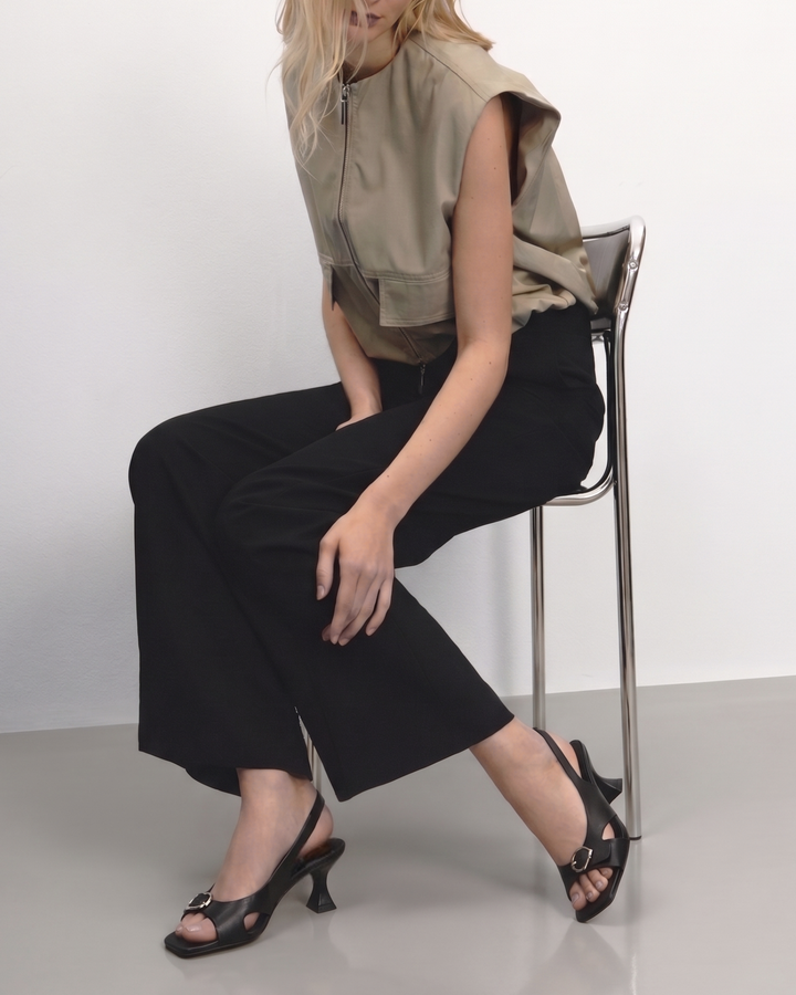 Modelo luciendo zapato destalonado negro con tacón chupete, punta cuadrada y hebilla plateada Dansi