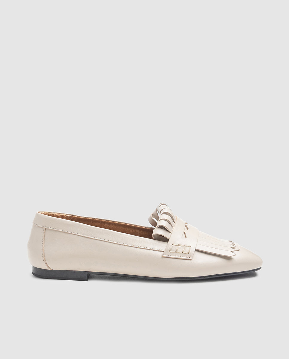 Vista de perfil del zapato plano Noa en piel color sabia con flecos y tacón de 1,5 cm